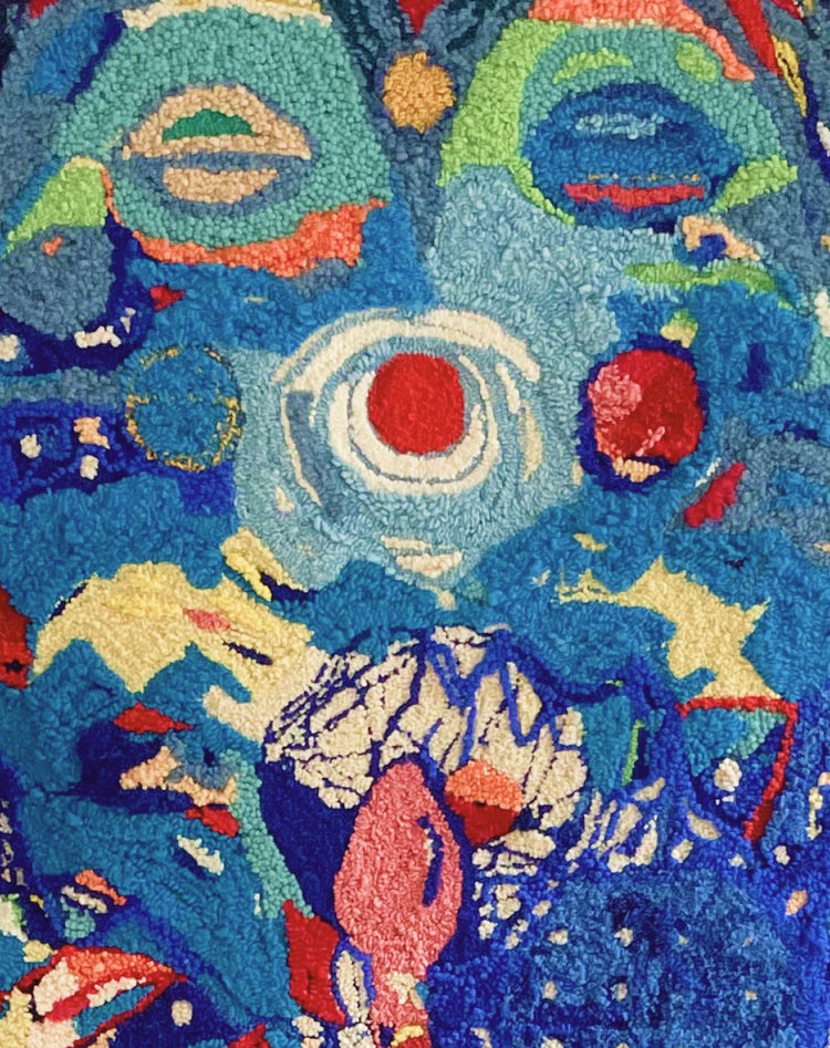 A close-up of a highly textured, abstract loop-pile rug featuring a vibrant multicolor design with blue, red, green, yellow, and white organic shapes.