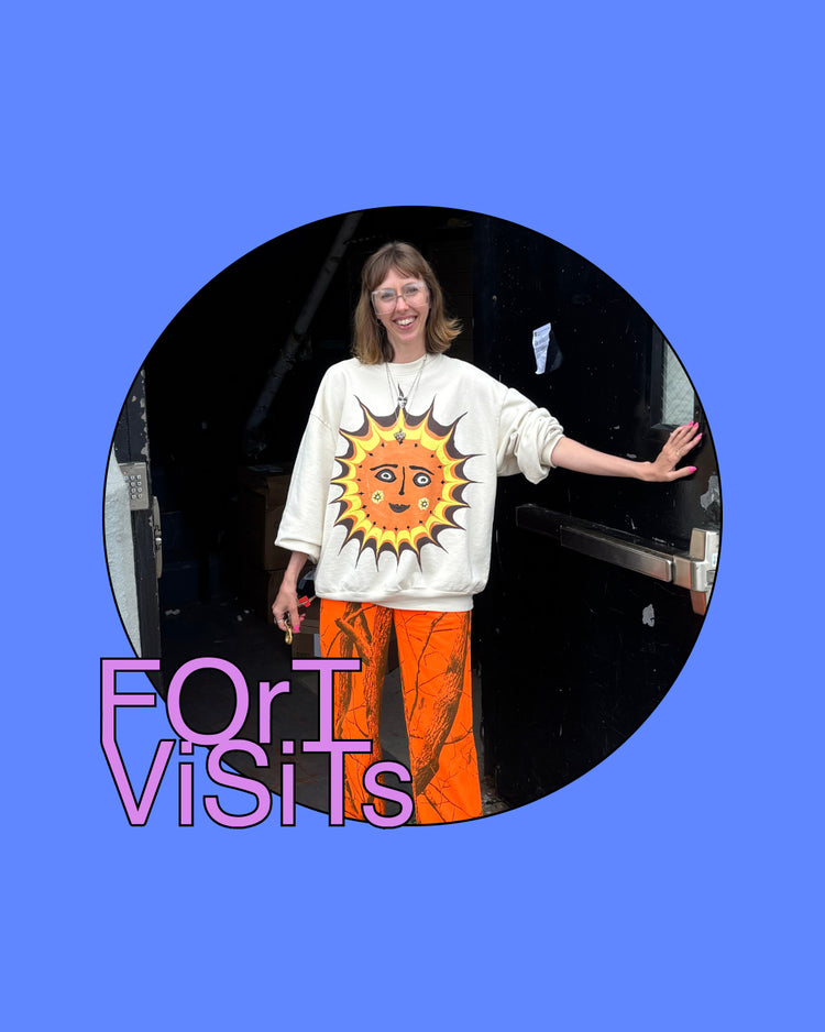 A circular inset photo of a woman wearing a cream sweatshirt with a large smiling sun graphic and bright orange pants, set against a solid blue background with the text 'FORT ViSiTs' in pink and purple.